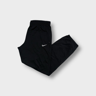 Black Nike trackpants featuring a white embroidered Swoosh logo on the upper leg