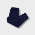 Nike navy blue trackpants featuring a small embroidered swoosh logo on the upper left leg.