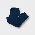 Navy blue Adidas trackpants featuring a small white embroidered logo on the upper leg