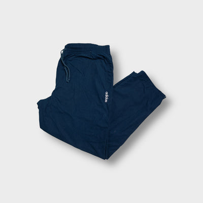 Navy blue Adidas trackpants featuring a small white embroidered logo on the upper leg