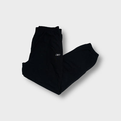 Reebok trackpants in navy blue featuring an embroidered vector logo on the upper leg
