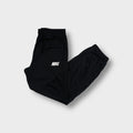Nike trackpants in black featuring a white printed wordmark logo on the thigh