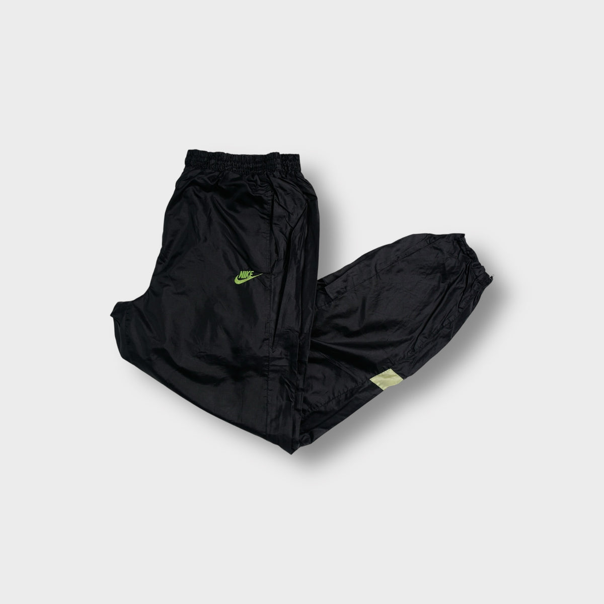 Black Nike trackpants with neon green embroidered logo and pink side panels