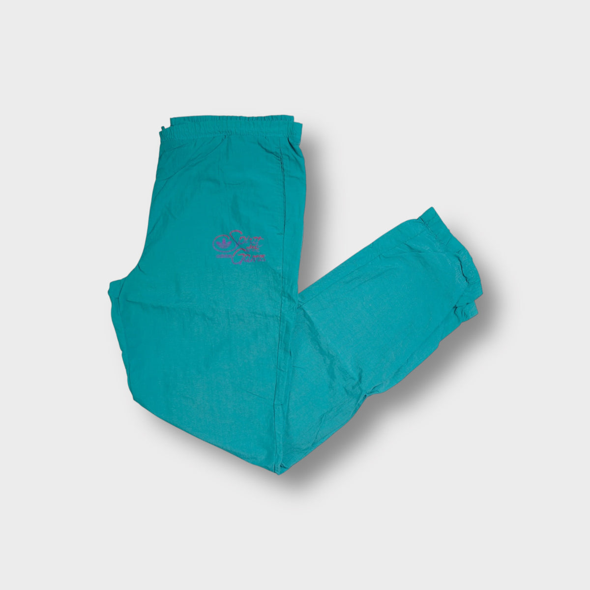Adidas turquoise trackpants with pink Spirit of the Games embroidery on hip