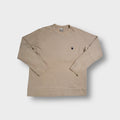 Beige Nike ribbed knit sweater featuring a small oval swoosh patch on the chest