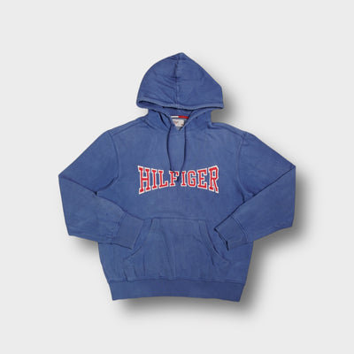 Blue Tommy Hilfiger pullover hoodie with red and white stitched Hilfiger chest appliqué.