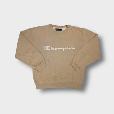 Champion sweater in beige featuring large embroidered script logo across the chest and crew neck.