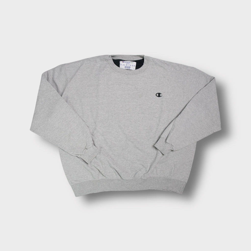 Grey Champion sweater with small embroidered logo on chest and ribbed cuffs.
