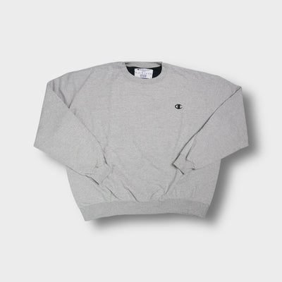 Grey Champion sweater with small embroidered logo on chest and ribbed cuffs.