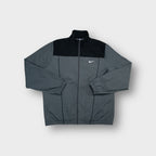 Nike track jacket in grey featuring an embroidered white swoosh logo on the chest