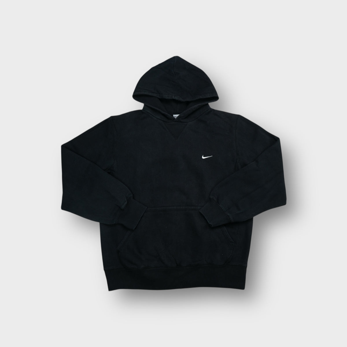 Nike pullover hoodie in black featuring small white embroidered swoosh on left chest