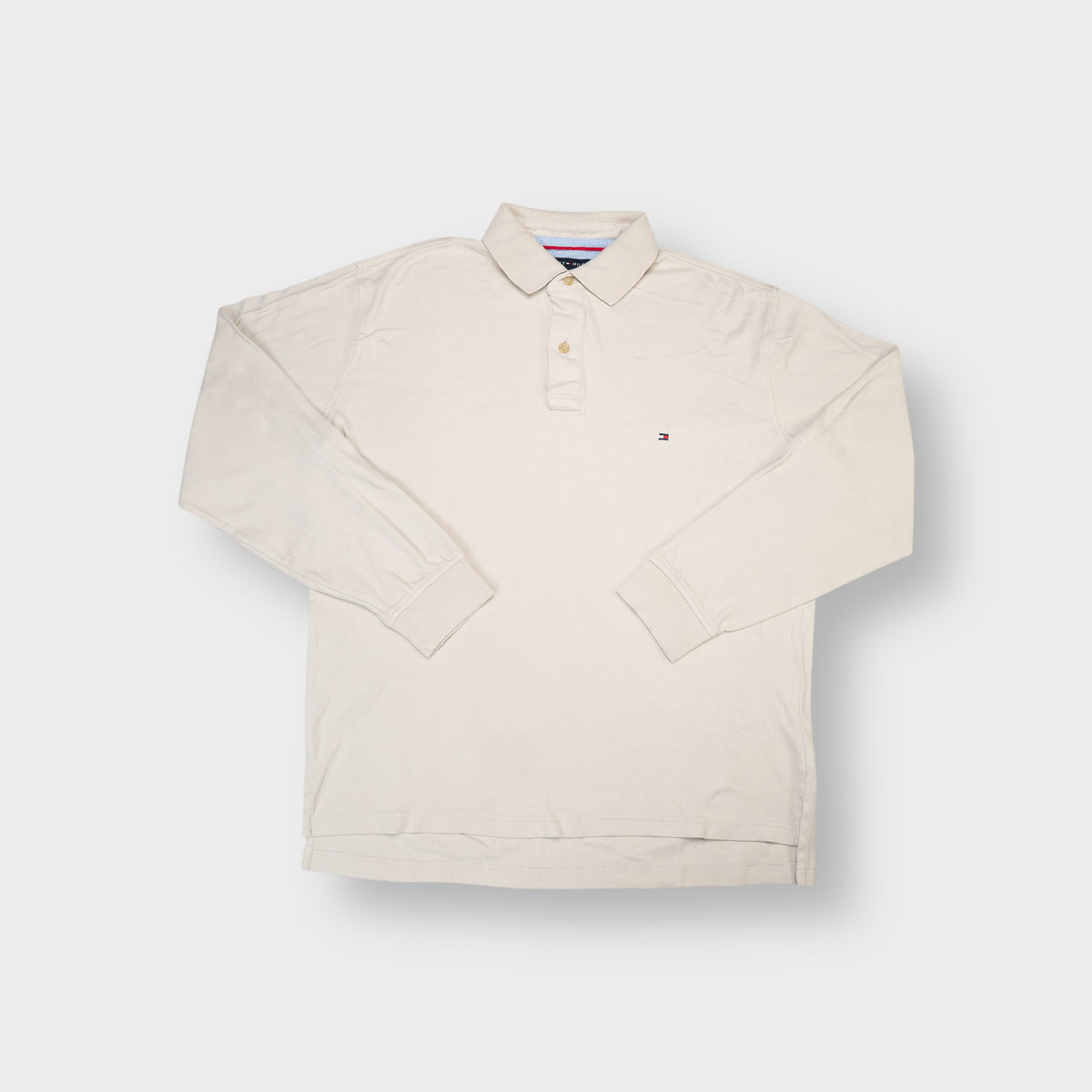 Tommy Hilfiger long-sleeve polo shirt in beige with embroidered flag logo on the chest.