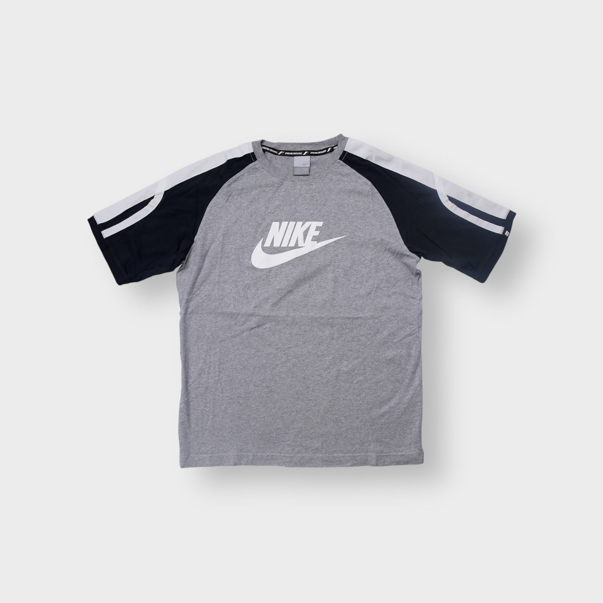 Nike T-Shirt in grey and black featuring a large white logo print on the chest