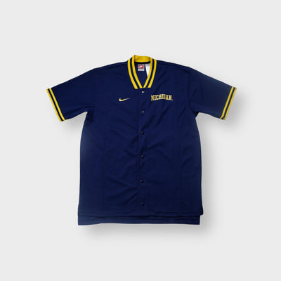 Nike short-sleeve jersey in navy with yellow ribbed collar and embroidered Michigan logo