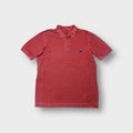 Nike polo shirt in red featuring a small blue swoosh patch on the chest