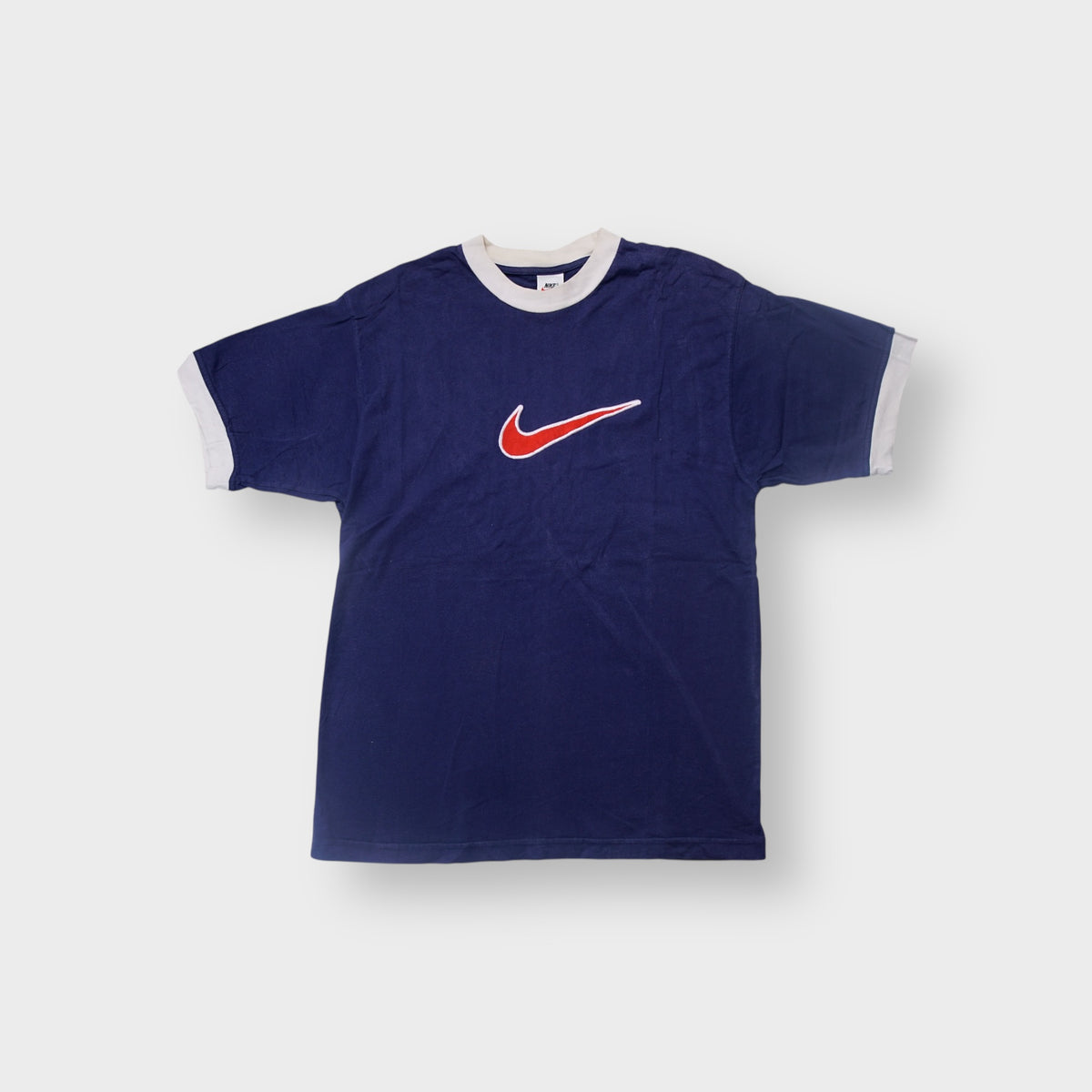 Nike T-Shirt in blue and white with a central embroidered red swoosh patch