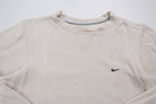 Nike crewneck sweater in beige featuring a small black embroidered Swoosh logo on the chest, full view
