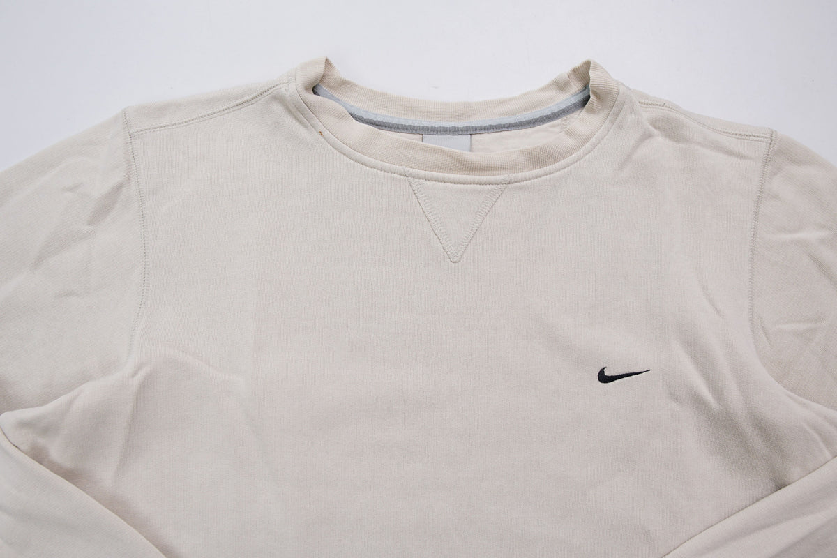 Nike crewneck sweater in beige featuring a small black embroidered Swoosh logo on the chest, full view