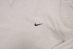 Nike crewneck sweater in beige featuring a small black embroidered Swoosh logo on the chest, detail