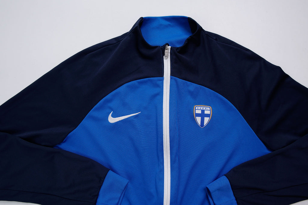 Nike track jacket in blue and navy featuring the Suomi crest on the chest, full view