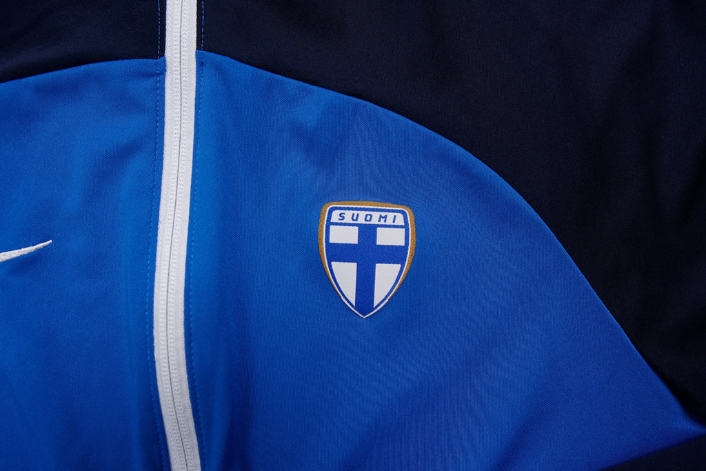 Nike track jacket in blue and navy featuring the Suomi crest on the chest, detail