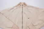 Nike zip jacket in beige featuring a small navy embroidered swoosh on the chest, full view