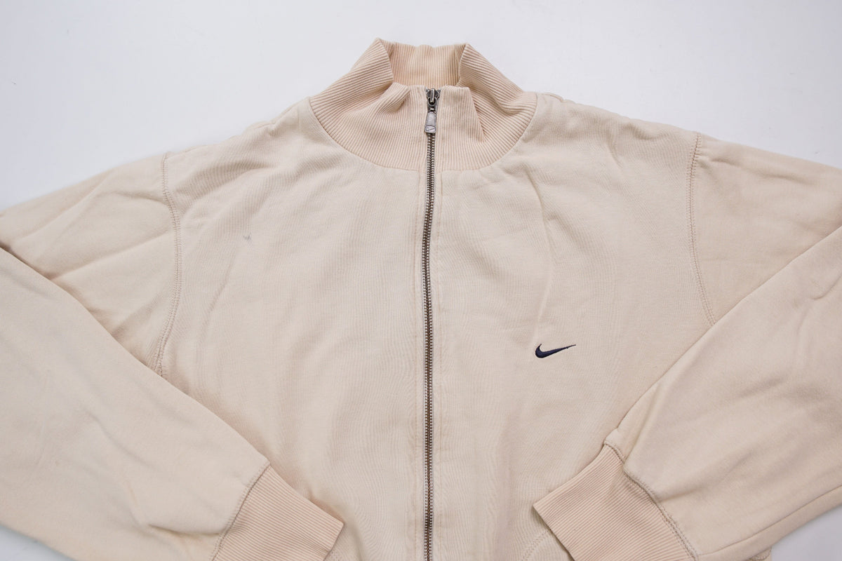 Nike zip jacket in beige featuring a small navy embroidered swoosh on the chest, full view