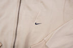Nike zip jacket in beige featuring a small navy embroidered swoosh on the chest, detail