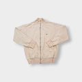 Nike zip jacket in beige featuring a small navy embroidered swoosh on the chest