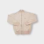 Nike zip jacket in beige featuring a small navy embroidered swoosh on the chest