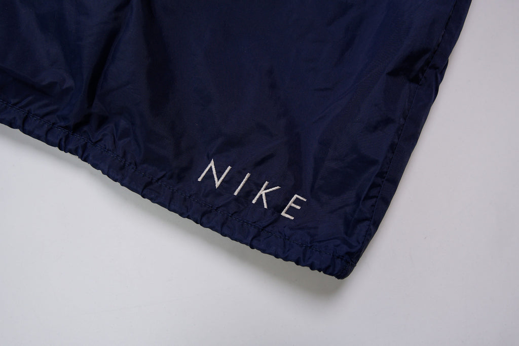 Nike navy jacket featuring a white chest stripe, hooded half-zip, and small embroidered swoosh, detail 4