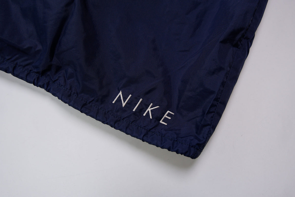 Nike navy jacket featuring a white chest stripe, hooded half-zip, and small embroidered swoosh, detail 4