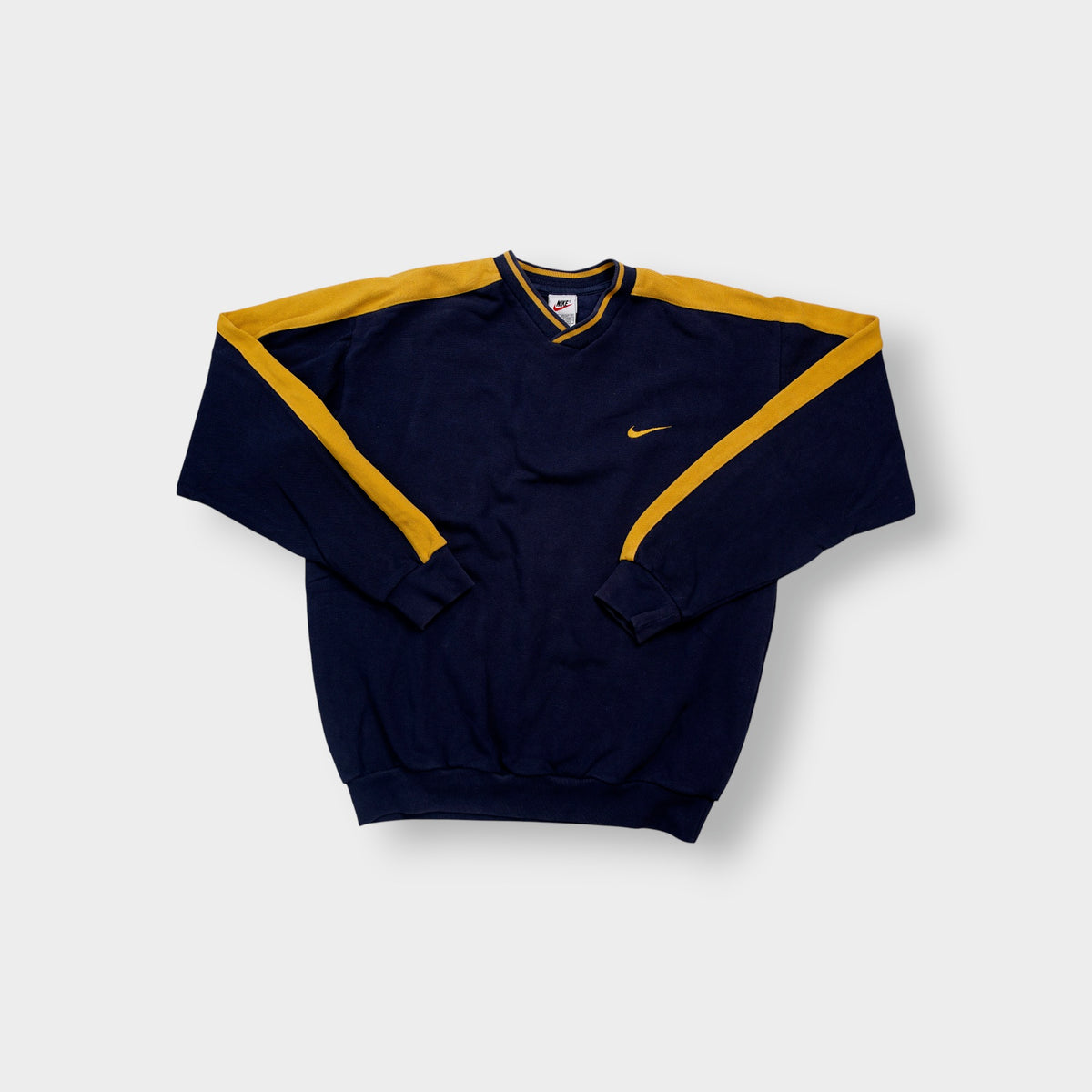 Nike navy and yellow V-neck sweater with yellow sleeve stripes and embroidered swoosh