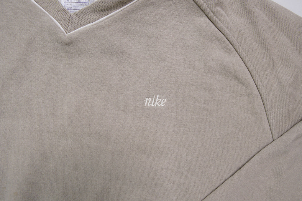 Nike sweater in beige with V-neck detailing and small script embroidery, detail