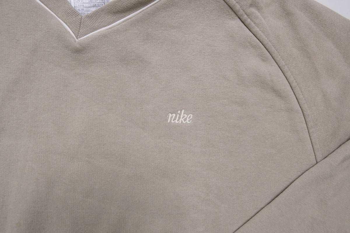 Nike sweater in beige with V-neck detailing and small script embroidery, detail