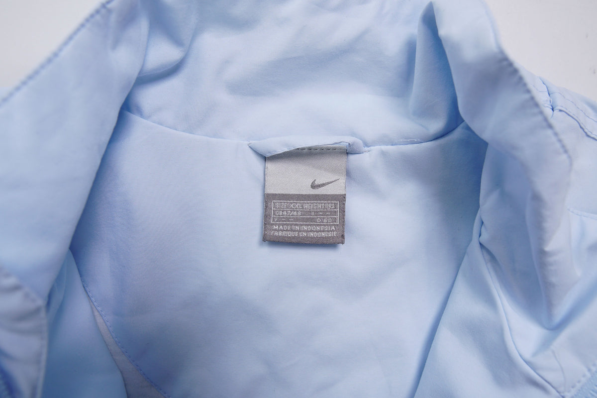 Nike light baby blue zip jacket with small white embroidered swoosh on the chest, size label