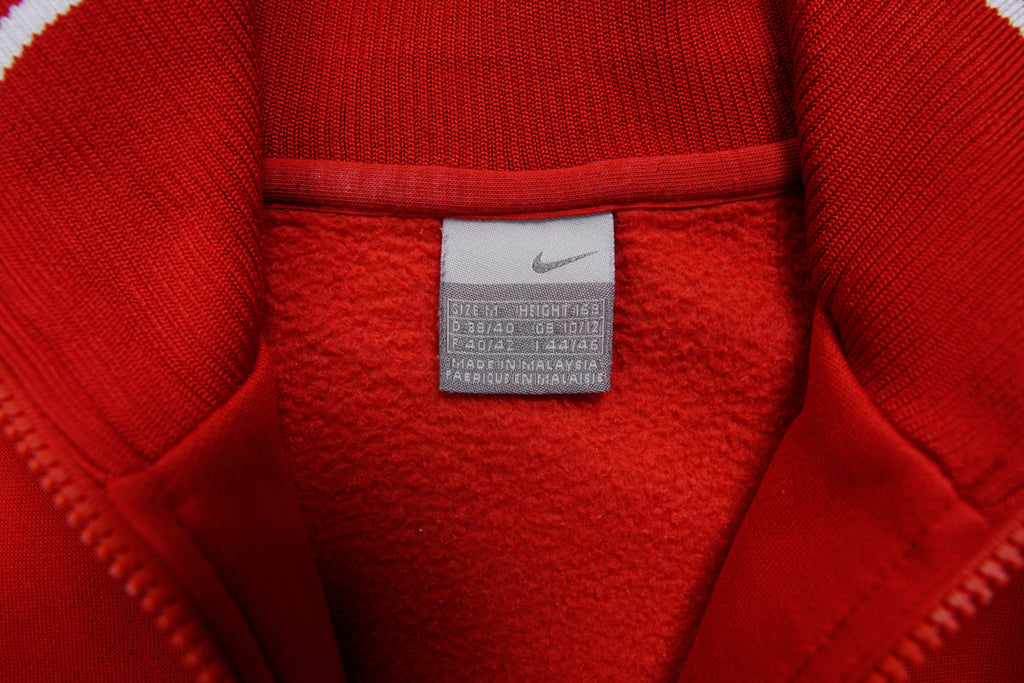 Nike track jacket in red and orange featuring a ring zipper pull and ribbed collar, size label