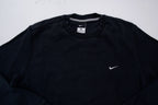 Nike sweater in black with small white embroidered swoosh on left chest, detail