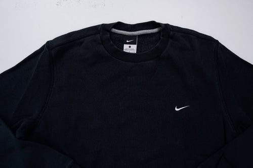 Nike sweater in black with small white embroidered swoosh on left chest, detail