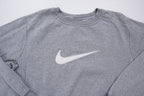 Nike crewneck sweater in grey with a large white embroidered swoosh applique on the chest, full view