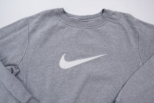 Nike crewneck sweater in grey with a large white embroidered swoosh applique on the chest, full view