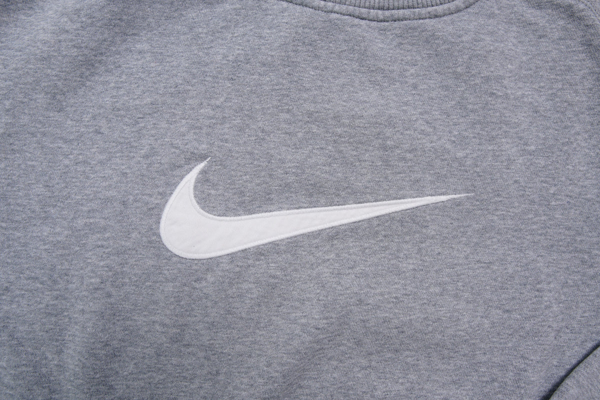 Nike crewneck sweater in grey with a large white embroidered swoosh applique on the chest, detail