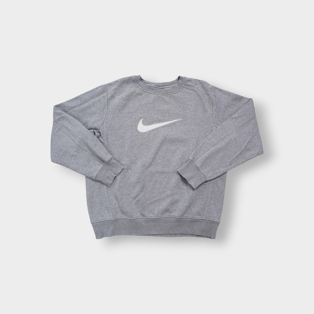 Nike crewneck sweater in grey with a large white embroidered swoosh applique on the chest