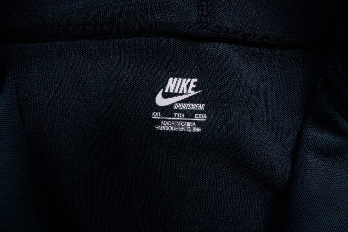 Nike track jacket in black featuring an embroidered swoosh logo on the chest, size label