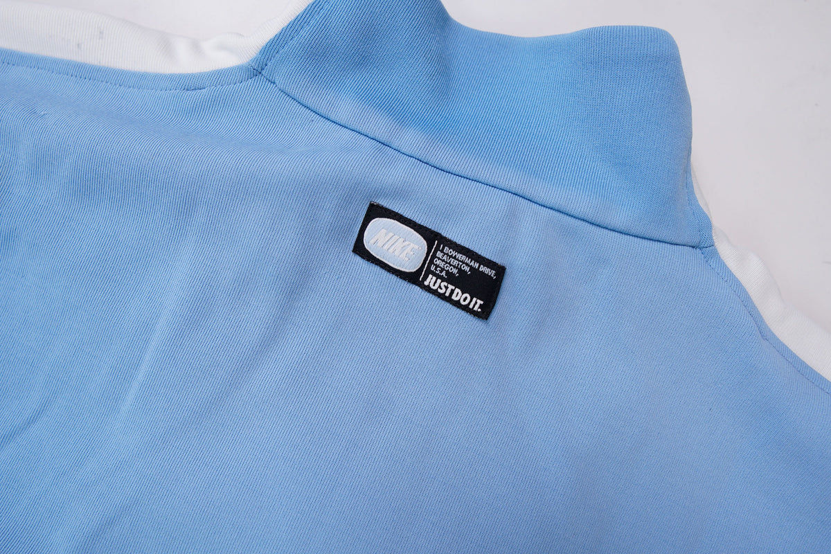 Light blue Nike jacket with red shoulder stripes and embroidered chest logo, detail 3