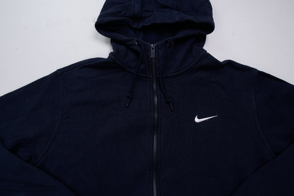 Nike zip hoodie in dark blue with embroidered white Swoosh logo on chest, detail