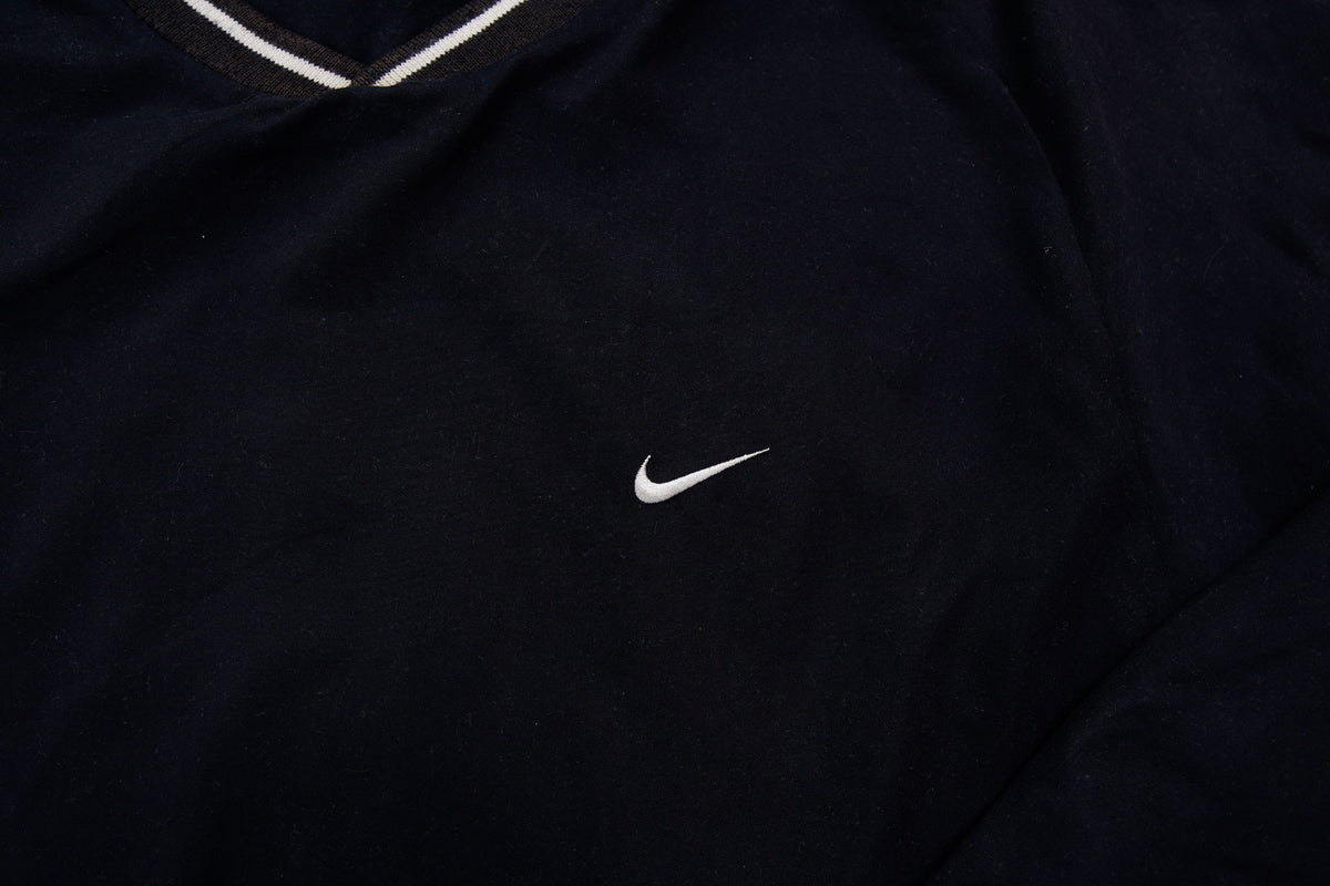 Nike Golf sweater in black with a V-neck collar and a small white embroidered swoosh, detail