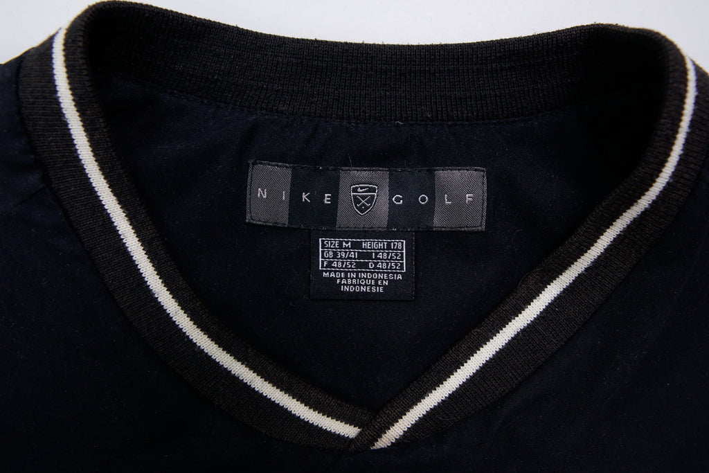 Nike Golf sweater in black with a V-neck collar and a small white embroidered swoosh, size label