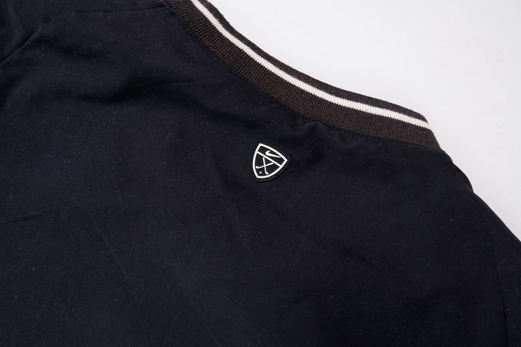 Nike Golf sweater in black with a V-neck collar and a small white embroidered swoosh, detail 2