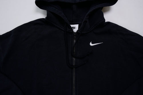 Black Nike zip jacket featuring a hood and embroidered white Swoosh on chest, detail